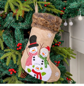 Hanging burlap Christmas stocking with three snowmen and faux fur trim on a decorated tree