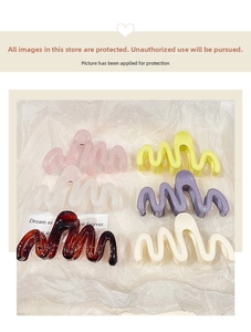 Flat lay of six colorful wavy hair claws in jelly tones on white textured background