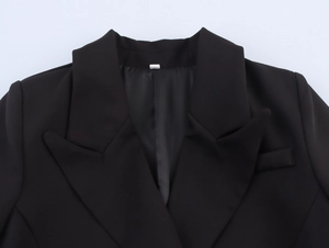 Detail view of peak lapel design on black double-breasted relaxed fit blazer