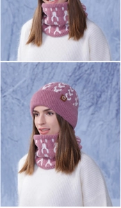 Close-up of pink knitted winter hat and scarf set with geometric patterns for warmth