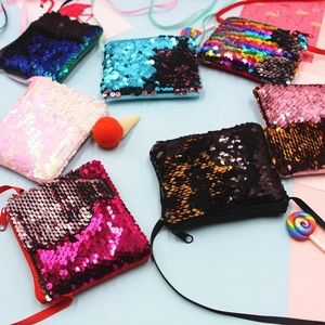 Colorful reversible mermaid sequin crossbody coin purses for children shown in a flat lay.