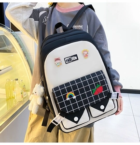 Detail of checkered backpack with cute cartoon badges and plush bear accessory
