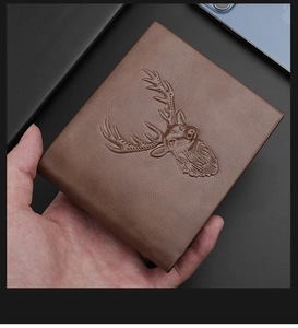 Nahaufnahme einer braunen Lederbörse mit detailliertem geprägtem Hirschkopf-Logo-Design