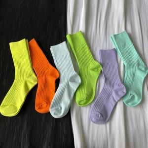 Flat lay of colorful ribbed cotton crew socks in neon yellow, orange, and green colors