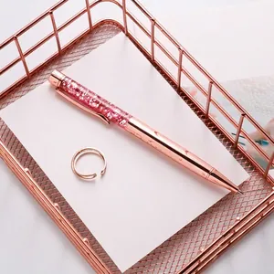 Rose gold ballpoint pen with pink glitter quicksand decor in metal storage basket