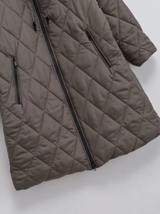 Detail of diamond quilted dark coffee jacket featuring smooth zipper and premium texture