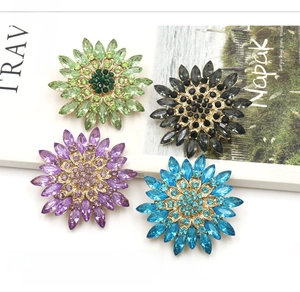 Close-up of sunflower brooches with colorful crystals and golden alloy setting