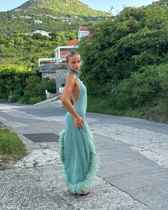 Detail of mint green backless halter dress featuring elegant feather trim and side slit