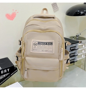 Detailed view of beige large-capacity backpack with functional zippers in a cozy study setting