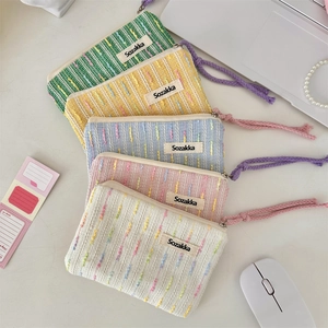 Detailed view of woven cosmetic pouches in pastel colors with vibrant zipper pulls