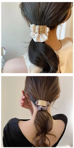 Détail de chouchous en soie avec boucles en métal doré en blanc et gris