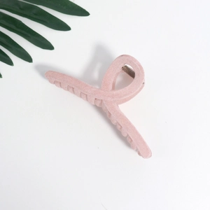 Close-up of a large pink velvet hair claw clip with a matte finish and metal spring