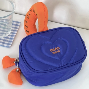 Dettaglio della borsa cosmetica trapuntata blu con manici arancioni e ricamo BEAR BEAR