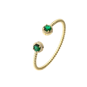 Minimalist gold open cuff bracelet featuring two green gemstones with sparkling diamond halos