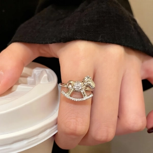 Detailed view of silver rocking horse ring with pavé-set cubic zirconia on finger