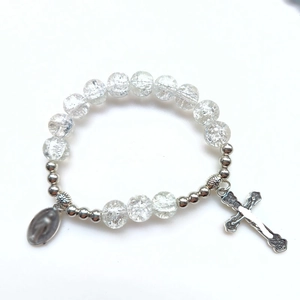 Dettaglio del bracciale con perle in vetro crackle, ciondolo a croce e medaglia ritratto