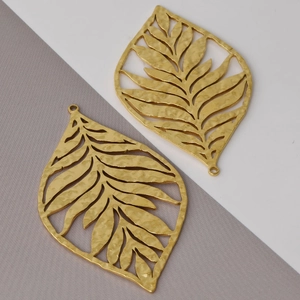 Macro detail of 304 stainless steel gold leaf pendants with hammered texture and hollow design