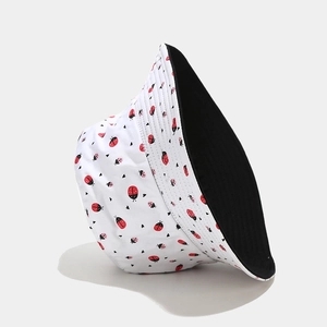 Close-up of double-sided bucket hat featuring red ladybug prints and solid black lining