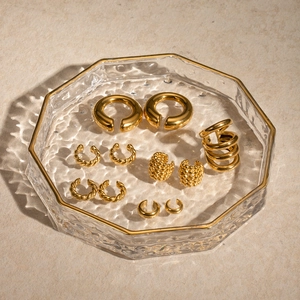 Set aus goldenen Vintage-Ohrklemmen mit glatten und gedrehten Mustern in Glastablett