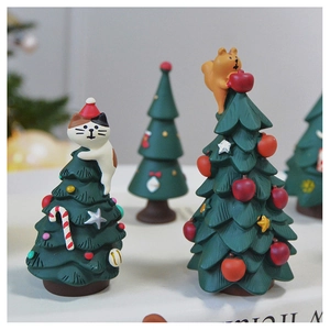 Detailed view of miniature resin Christmas trees and cute cats for holiday tabletop decor
