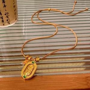 Detail of gold-plated woven necklace featuring dragon relief pendant and Nafu lucky charm