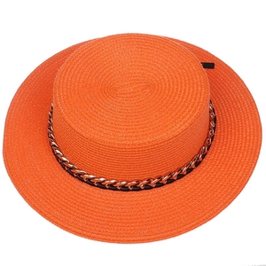 Detail of orange boater hat featuring a stylish black band and golden metal chain decoration
