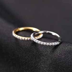 Macro shot of titanium double-layer gold and silver hoop earrings with micro-set pearls