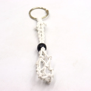 Detailed macro view of white hand-woven cotton macrame net bag for crystal necklace pendant