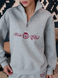 Detail of grey quarter-zip fleece sweatshirt with red Moda Club logo and collar