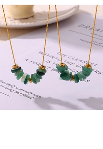 Macro shot of green gravel stone necklace with gold beads on elegant background