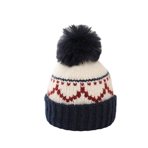 Kids knitted beanie with navy pompom and red heart patterns on cream background
