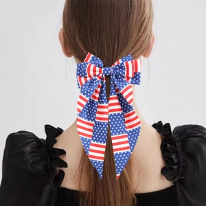 Independence Day hair bow with American flag pattern and long ribbons on ponytail