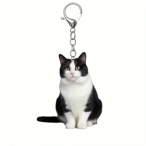 Detail of silver metal lobster clasp and acrylic black and white tuxedo cat keychain