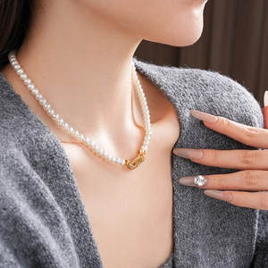 Close-up of a vintage pearl necklace with zircon-inlaid gold clasp on a female neck