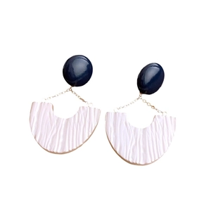 U-shaped pleated earrings with dark blue studs and white textured resin pendants