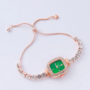 Detail of rose gold bracelet watch with green square dial and crystal accents