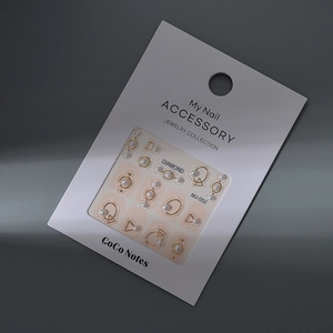 Macro shot of 3D pearl nail art accessories with gold metal rings on display card