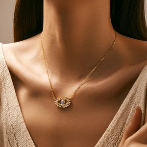 Elegant gold S925 silver blue eye necklace with clear cubic zirconia worn by a model