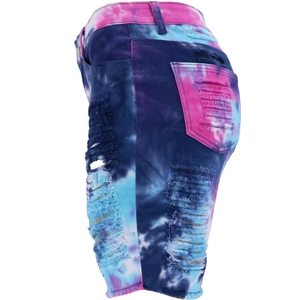 Detail of pink and blue tie-dye denim shorts featuring distressed holes and frayed hems