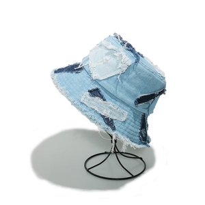Close-up of distressed denim bucket hat with frayed patchwork and fringe details