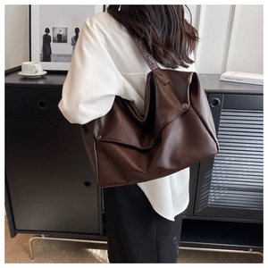 Detail of coffee brown pebbled leather tote bag showing large capacity and soft texture