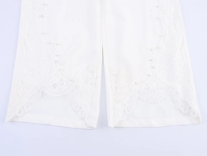 Gros plan du pantalon blanc avec broderie en dentelle élégante et détails en perles