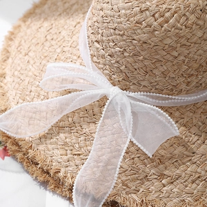 Chapeau de soleil en raphia à large bord avec bords effilochés et ruban d'organza blanc