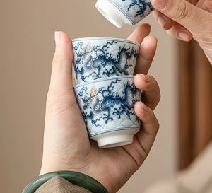 Macro shot of stacking ceramic tea cups with blue and white porcelain golden dragon motif