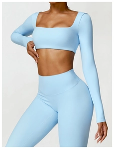 Detail of light blue tight long-sleeve yoga top and high-waist leggings with matte finish