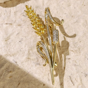 Macro shot of gold wheat brooch featuring yellow crystals and sparkling clear zircons