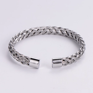Silver woven stainless steel cable cuff bracelet with polished end caps in a minimalist style