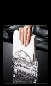 Vertical glass tissue holder with fan relief design on a dark marble tabletop scene