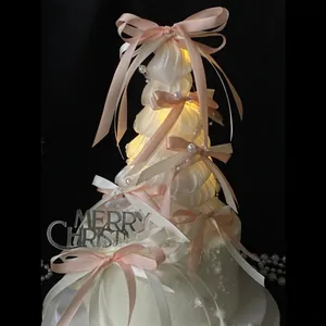 Luminous ballet style Christmas tree with pink silk bows and warm LED lights for decor