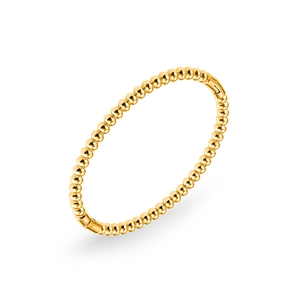 Detailed macro view of 18k gold plated beaded bangle with polished mirror finish